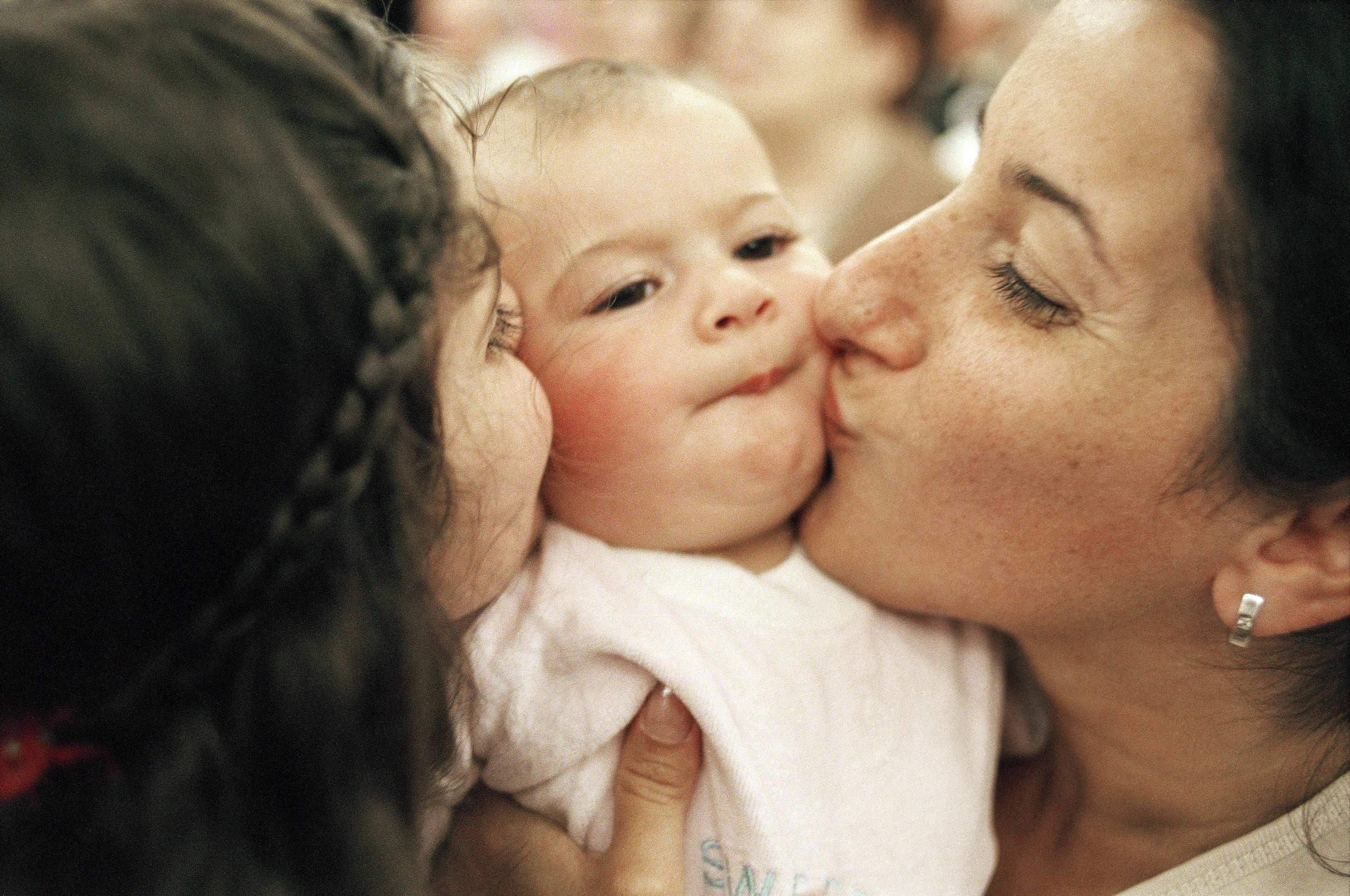 Baby Getting Kissed by Two Generations of Women